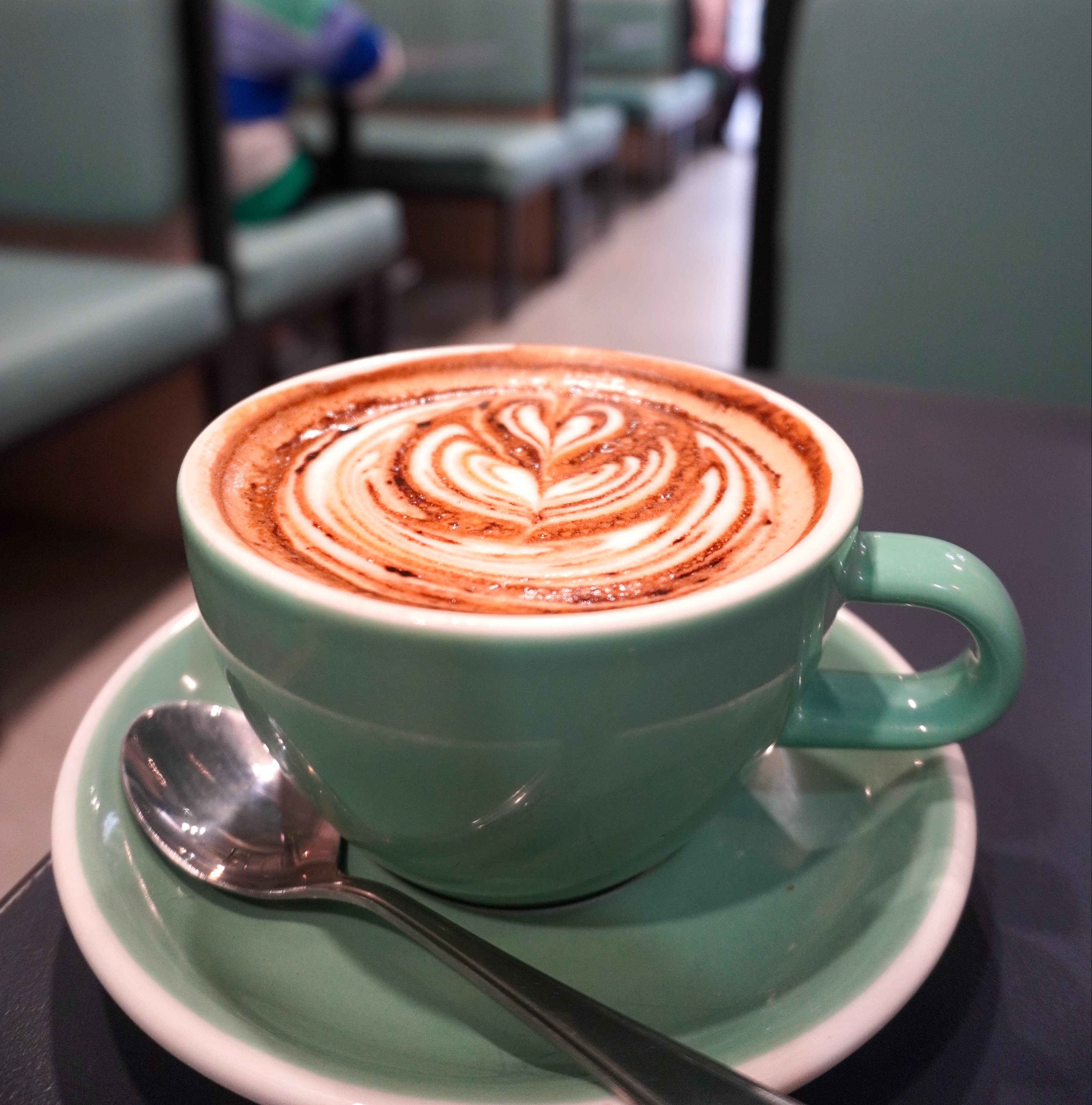 Latte art in a green ceramic cup at JJ's Eatery
